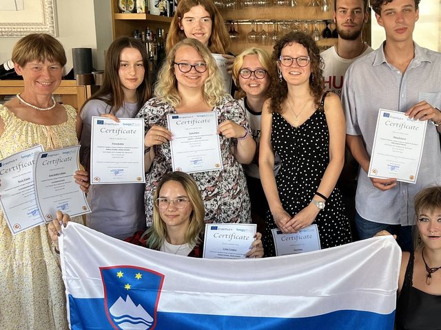 Group with the Slovenian flag and their certificates