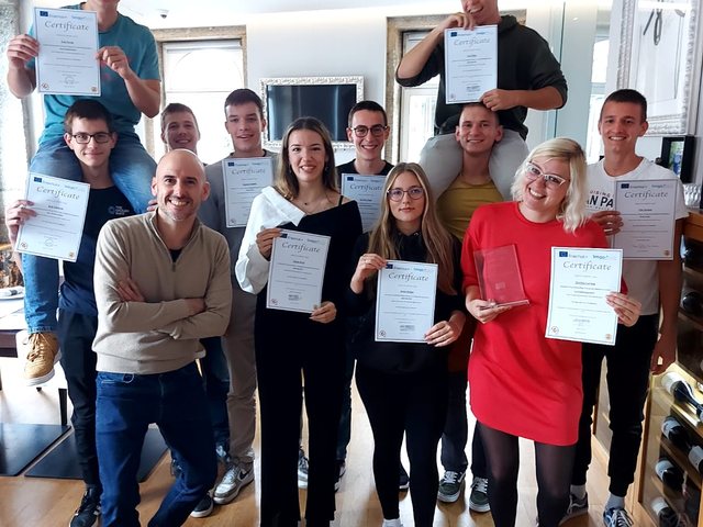 Group with their certificates in a restaurant