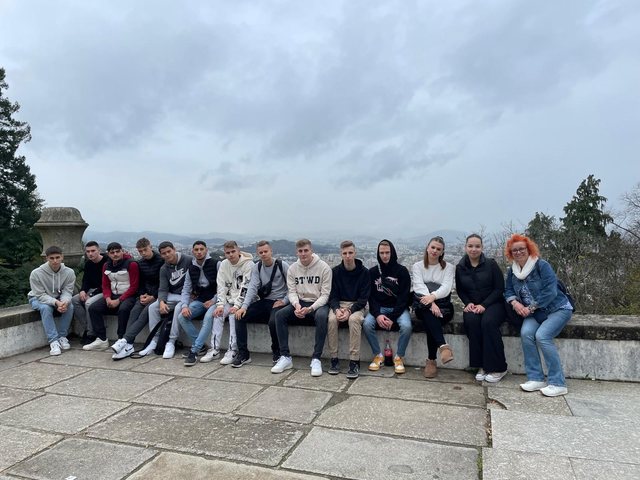 Group sitting on a wall at a viewpoint over Braga