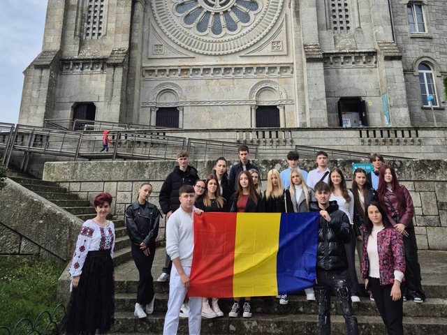 Group with the Romanian flag in front of a sanctuary