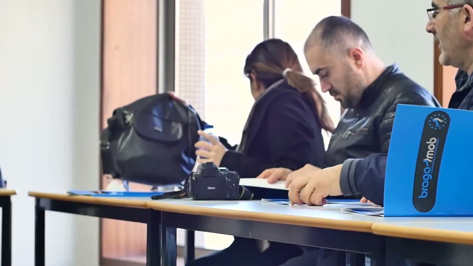 Coordinators reviewing documents around a table (frame from the BragaMob video)